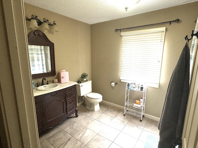 bathroom featuring vanity, a textured ceiling, and toilet