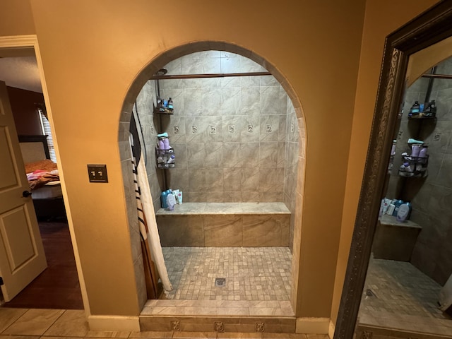 bathroom featuring tiled shower and tile patterned floors