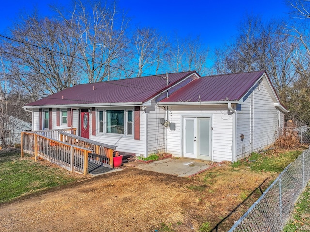 rear view of property with a patio area, fence, metal roof, and a lawn