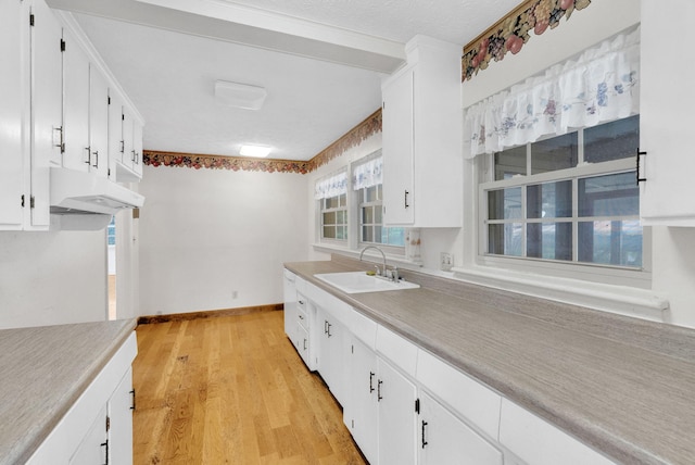 kitchen featuring white cabinetry, sink, and light hardwood / wood-style floors