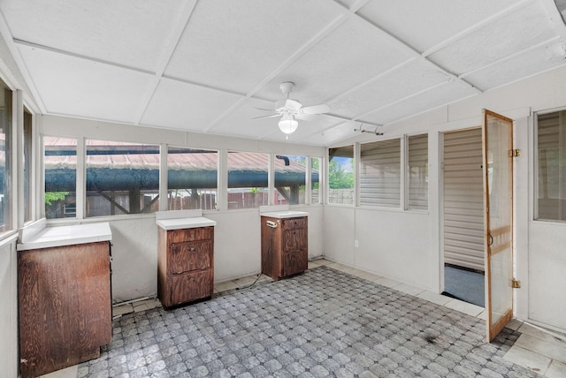 unfurnished sunroom with ceiling fan