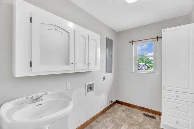 clothes washing area featuring cabinets, electric panel, sink, washer hookup, and hookup for an electric dryer