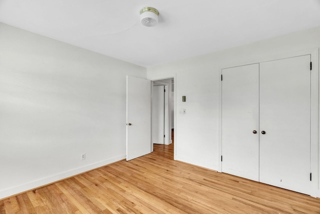 unfurnished bedroom with light hardwood / wood-style flooring and a closet