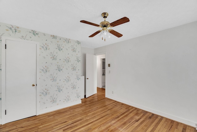 empty room with ceiling fan and light wood-type flooring