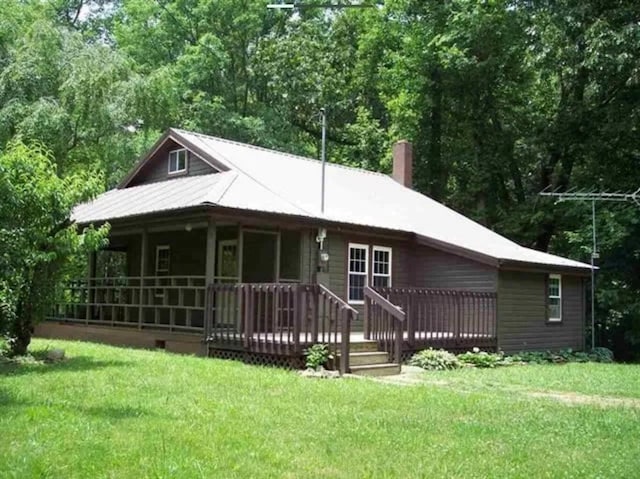 rear view of property featuring a lawn and a deck