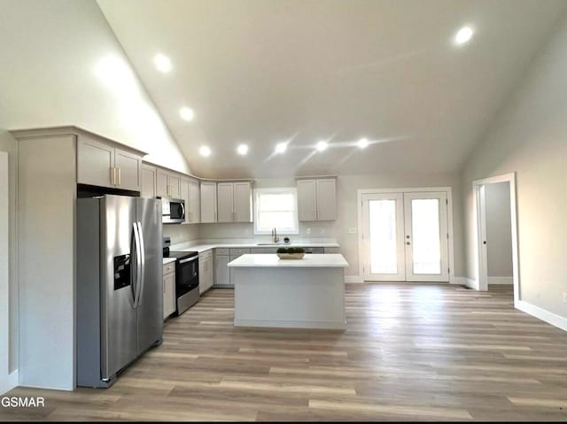 kitchen featuring a sink, a kitchen island, stainless steel appliances, french doors, and light countertops