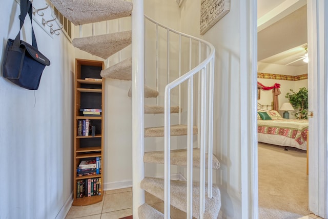 stairway with a textured ceiling, baseboards, and tile patterned floors