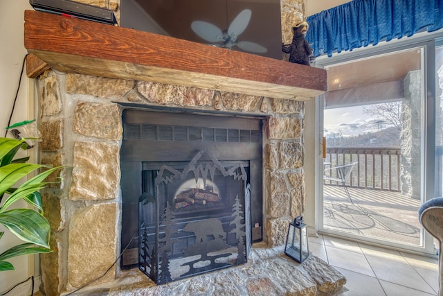 room details featuring ceiling fan and a fireplace