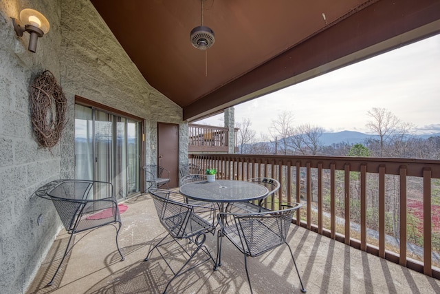 balcony with outdoor dining space and a mountain view