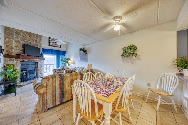 dining room featuring light tile patterned floors, ceiling fan, baseboards, and a textured ceiling