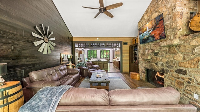 1115 Old Cartertown Rd, Road, Gatlinburg, TN 37738 - living room featuring a ceiling fan, wooden walls, lofted ceiling, wood finished floors, and a stone fireplace