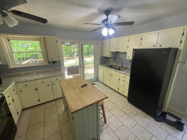 4124 Big Creek Rd, Hartford, TN 37753 - kitchen with freestanding refrigerator, a sink, a ceiling fan, tasteful backsplash, and light tile patterned floors