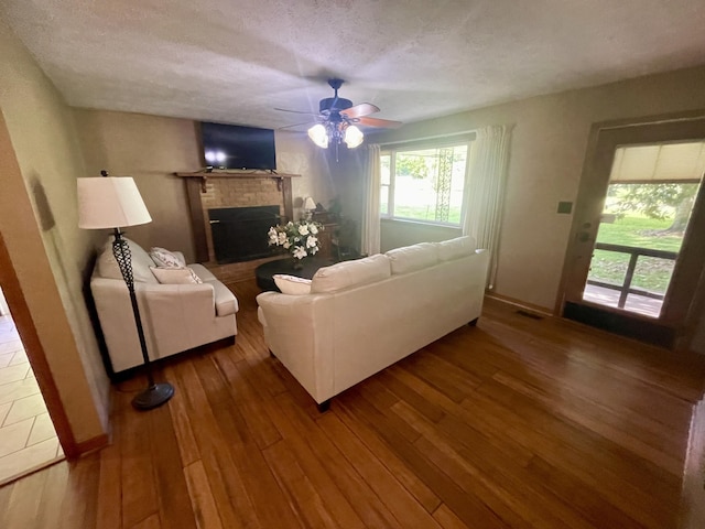 4124 Big Creek Rd, Hartford, TN 37753 - living area with a fireplace, wood finished floors, ceiling fan, and a textured ceiling