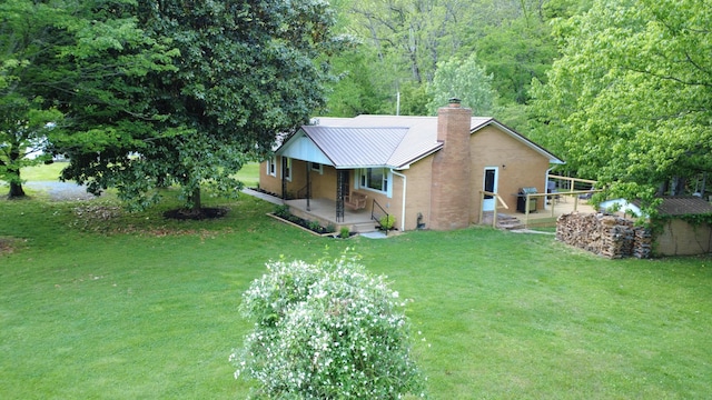 4124 Big Creek Rd, Hartford, TN 37753 - view of front facade with a chimney, a front yard, an outbuilding, a porch, and metal roof