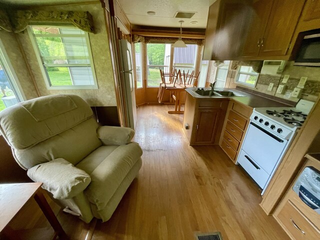 4124 Big Creek Rd, Hartford, TN 37753 - kitchen with white appliances, a sink, light wood-style floors, pendant lighting, and brown cabinetry