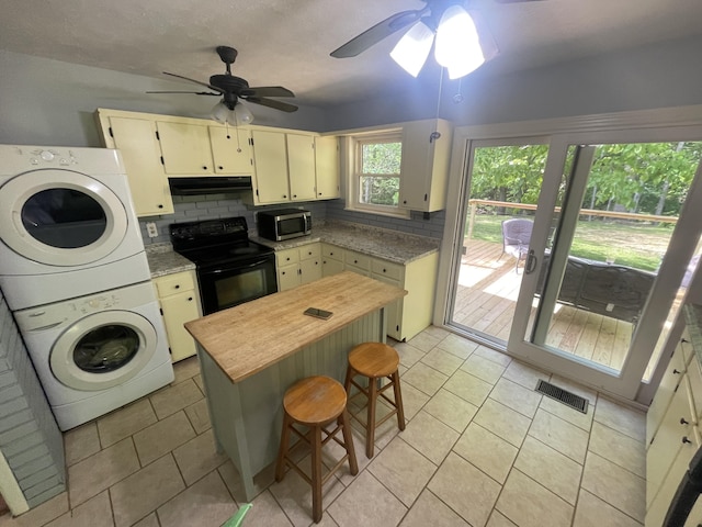 4124 Big Creek Rd, Hartford, TN 37753 - kitchen featuring electric range, stacked washer / dryer, stainless steel microwave, under cabinet range hood, and a ceiling fan