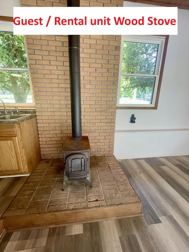 4124 Big Creek Rd, Hartford, TN 37753 - detailed view of a sink, wood finished floors, brick wall, and a wood stove