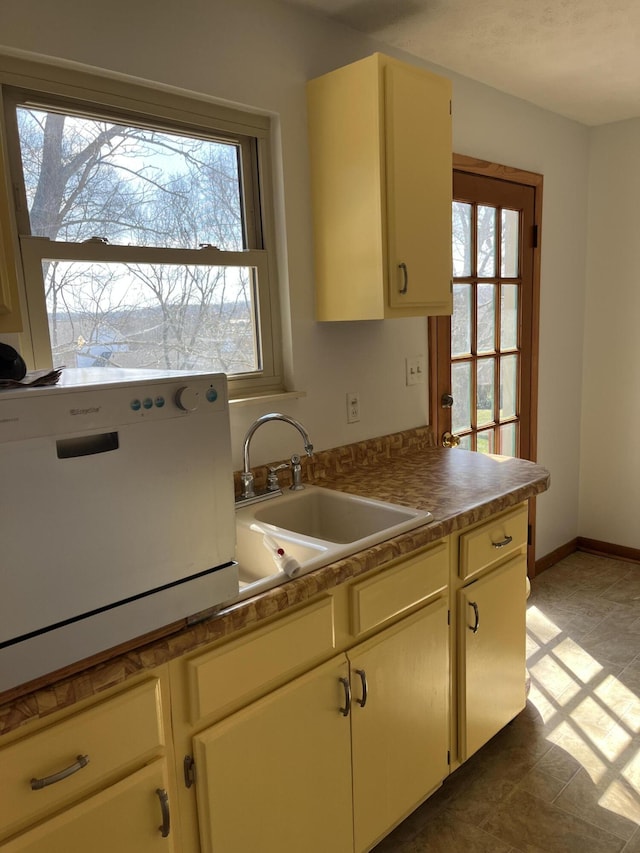 kitchen featuring a wealth of natural light, a sink, and baseboards