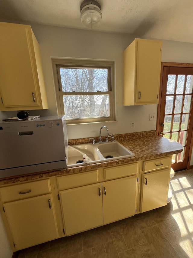 kitchen featuring dark countertops, a healthy amount of sunlight, and a sink