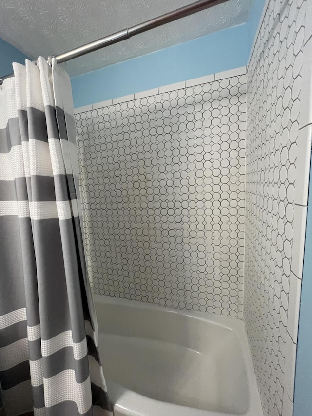 bathroom featuring a textured ceiling and shower / tub combo