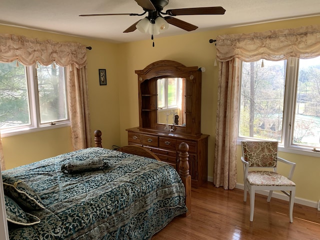 bedroom featuring ceiling fan, wood finished floors, and baseboards