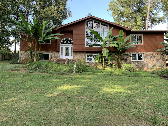 view of front of property with stone siding and a front lawn