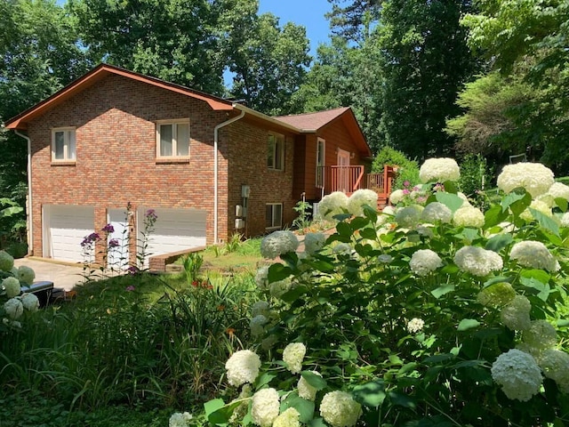 view of home's exterior featuring an attached garage, concrete driveway, and brick siding