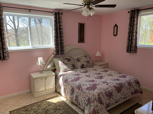 bedroom with light tile patterned floors, baseboards, and a ceiling fan