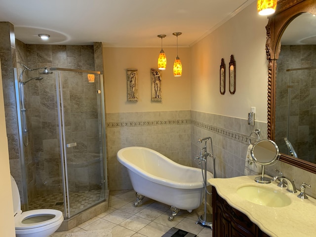 full bathroom featuring a freestanding tub, vanity, ornamental molding, a shower stall, and tile patterned floors