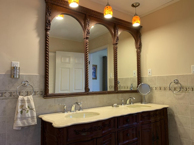 full bath featuring ornamental molding, a sink, tile walls, and double vanity