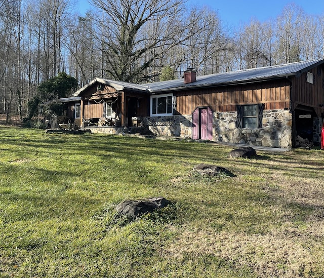 rear view of house featuring a yard