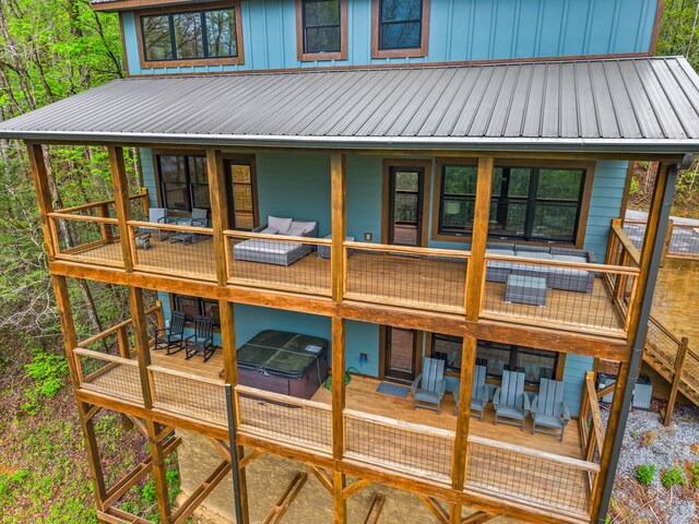 5276 Riversong Way, Sevierville, TN 37876 - back of house with a wooden deck, outdoor dining area, a hot tub, and metal roof