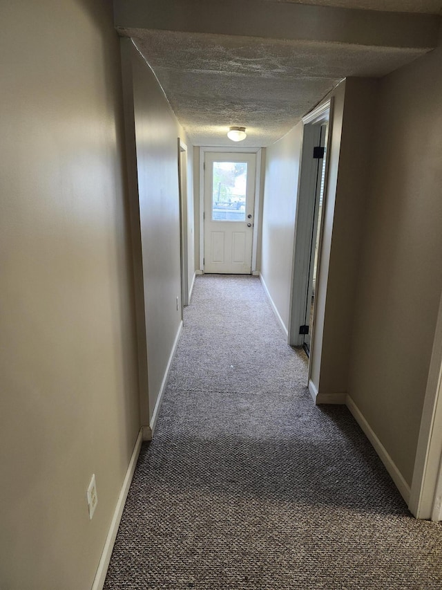 corridor with carpet and a textured ceiling