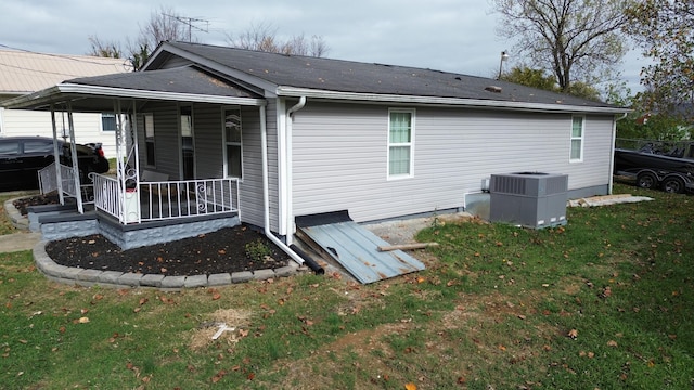 back of property featuring a porch, a yard, and central AC unit