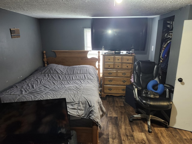 bedroom featuring a textured ceiling and dark wood-type flooring