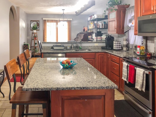 4815 Stapleton Rd, Morristown, TN 37813 - kitchen with appliances with stainless steel finishes, a peninsula, arched walkways, light stone countertops, and a kitchen island