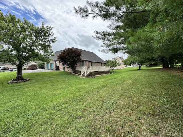 4815 Stapleton Rd, Morristown, TN 37813 - view of green lawn featuring a garage, a deck, and concrete driveway