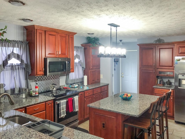 4815 Stapleton Rd, Morristown, TN 37813 - kitchen featuring stainless steel appliances, tasteful backsplash, dark brown cabinets, a kitchen island, and light stone countertops