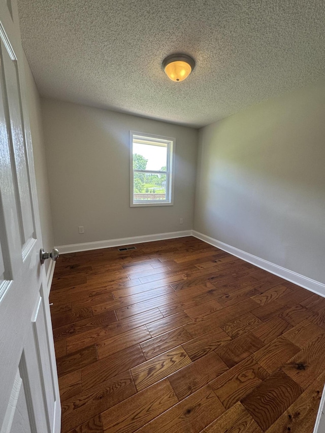 2276 White Oak Grove Rd, Morristown, TN 37813 - unfurnished room featuring a textured ceiling, dark wood-type flooring, and baseboards