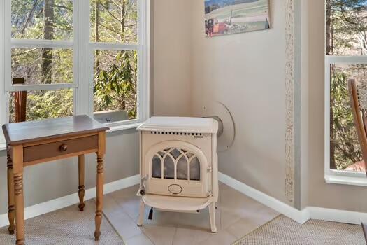 sitting room featuring a wood stove and baseboards