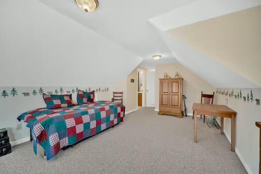 bedroom featuring lofted ceiling, carpet, and baseboards