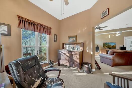 living area featuring baseboards, visible vents, a ceiling fan, and carpet flooring