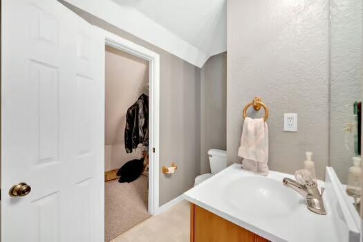 bathroom with a textured wall and vanity