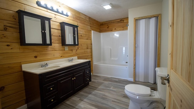 full bathroom with wooden walls, shower / washtub combination, a textured ceiling, and toilet