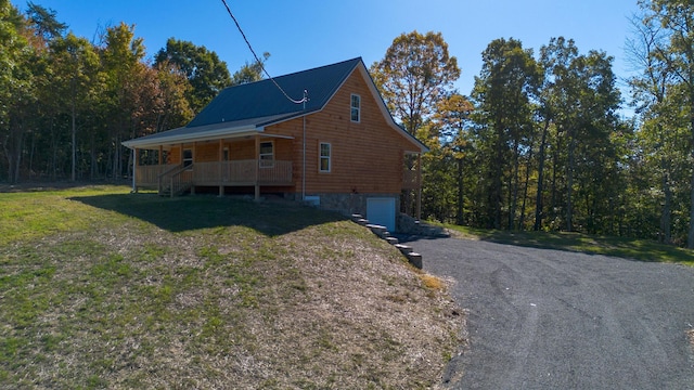 exterior space with covered porch, a garage, and a front yard