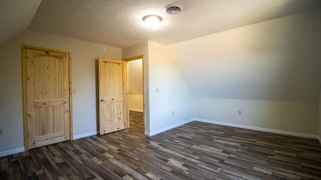 bonus room with dark hardwood / wood-style floors and vaulted ceiling