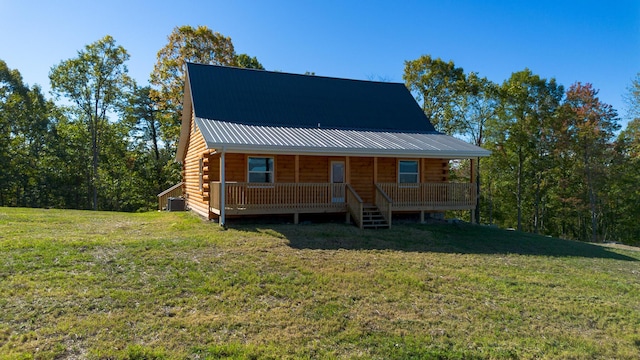 log cabin featuring central air condition unit and a front lawn