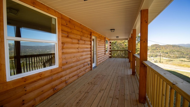 wooden deck with a mountain view and a porch