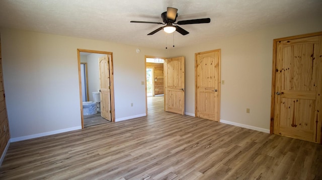 unfurnished bedroom featuring connected bathroom, ceiling fan, and light hardwood / wood-style flooring