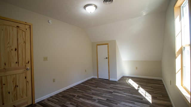 interior space with dark wood-type flooring and vaulted ceiling